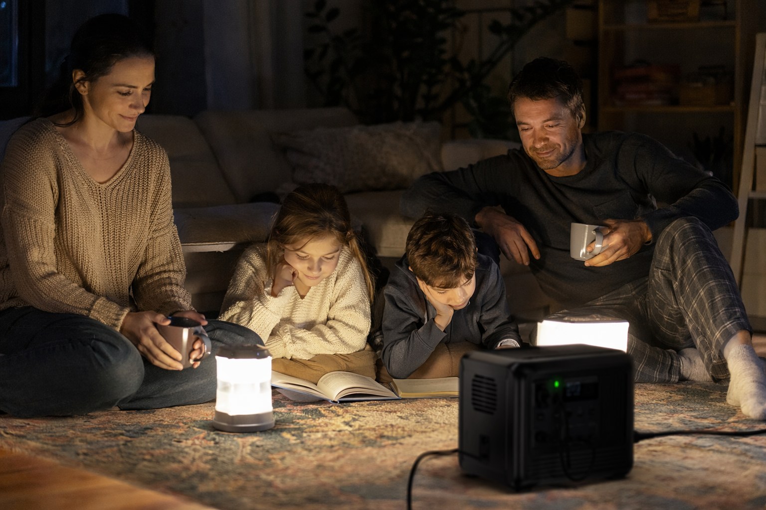 Family at home prepared and calm during a power outage, lit by a portable power station and LED lanterns